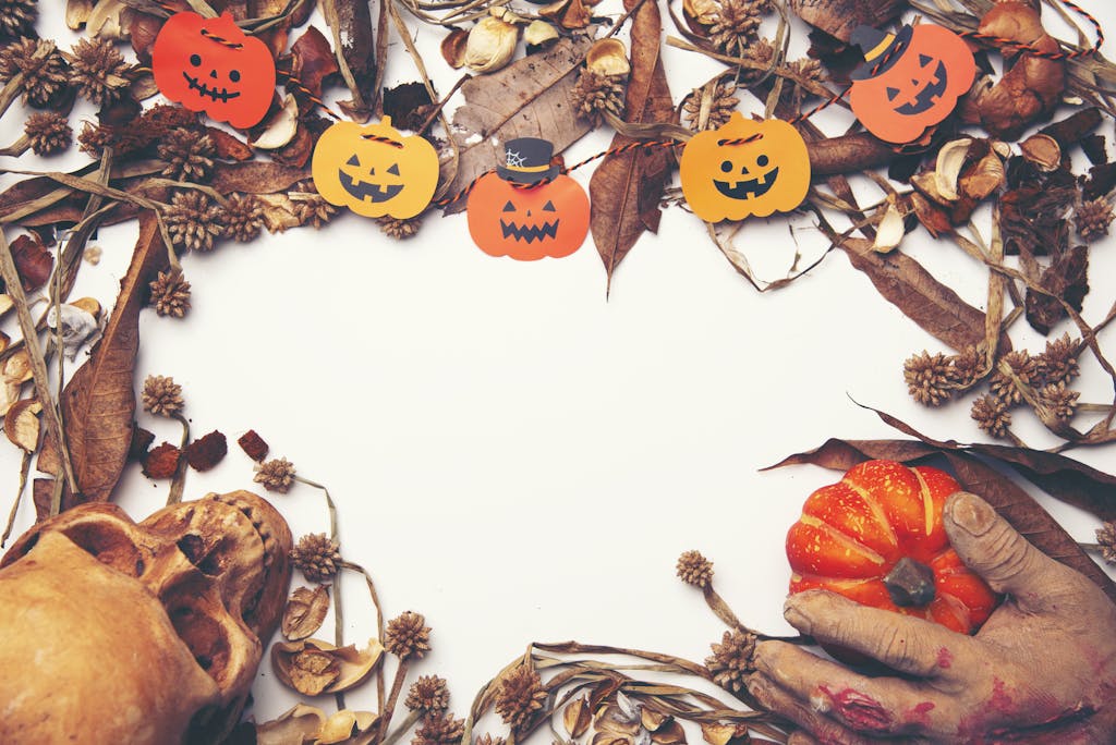 Spooky Halloween design featuring pumpkins, skull, and autumn leaves with copy space.